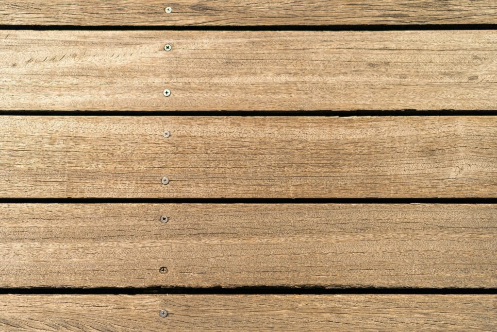 Close-up of clean wooden deck boards with visible screws and natural wood grain texture.
